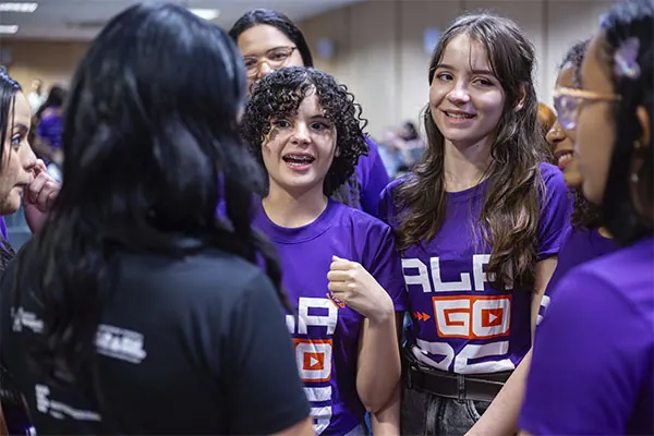 Alunas do Alagoas Tech, de camiseta roxa, conversam durante um encontro do programa, em Maceió (AL), 2025